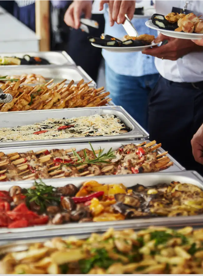 a group of people holding plates of food